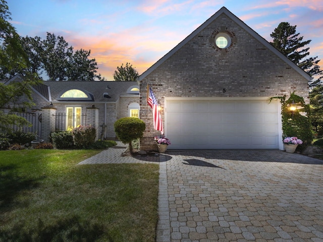 view of front of property with a garage and a lawn