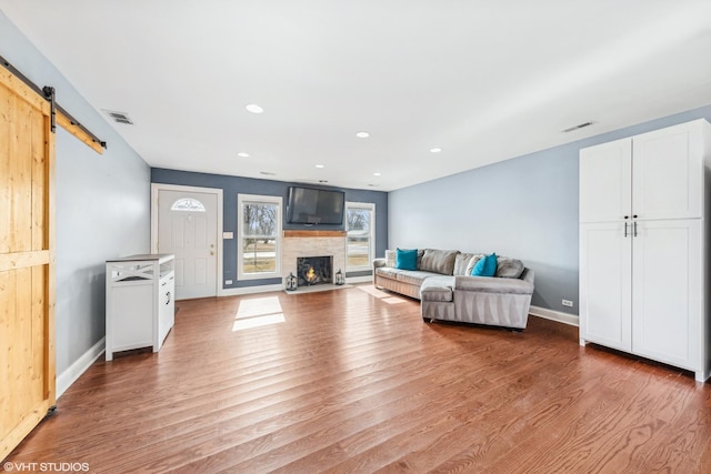 living room featuring a barn door and light hardwood / wood-style floors