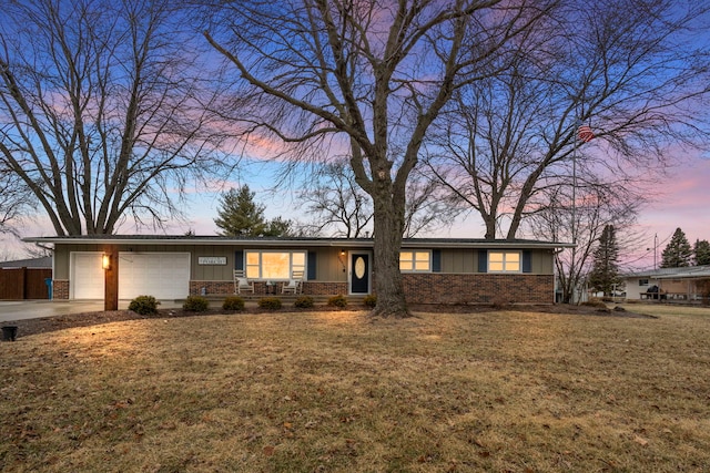 ranch-style house featuring a garage and a lawn