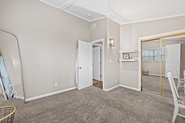 unfurnished bedroom with crown molding, vaulted ceiling, a closet, and carpet