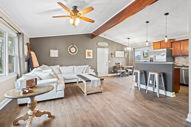 living room featuring dark hardwood / wood-style flooring, ceiling fan with notable chandelier, and vaulted ceiling with beams