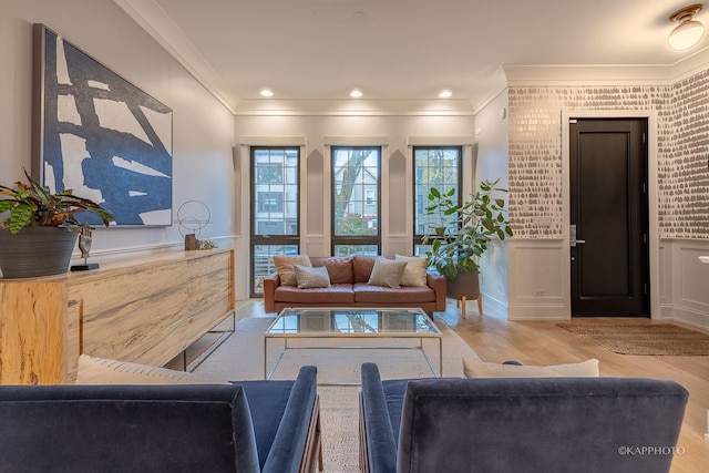 living room with ornamental molding, plenty of natural light, and light hardwood / wood-style floors