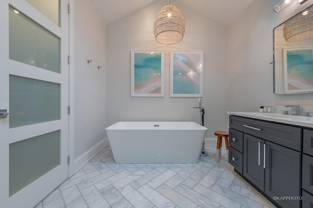 bathroom featuring lofted ceiling, vanity, and a washtub