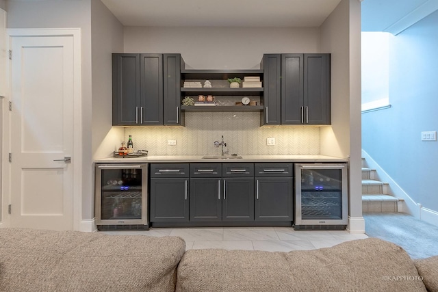 bar featuring sink, beverage cooler, and decorative backsplash