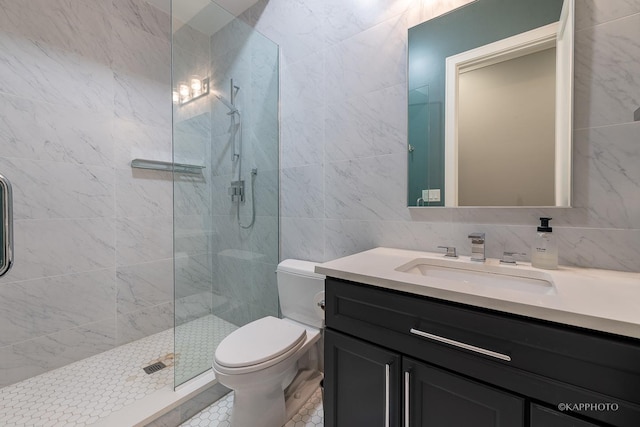 bathroom featuring a shower with door, tile walls, vanity, decorative backsplash, and toilet