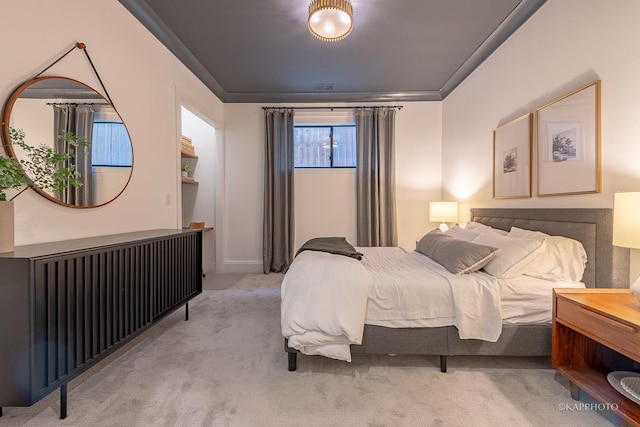 bedroom featuring crown molding and light colored carpet