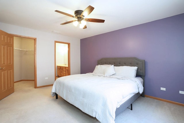 carpeted bedroom with ceiling fan, a walk in closet, and a closet