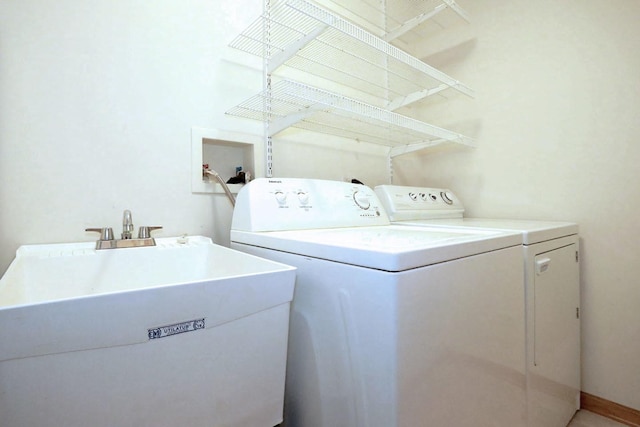 clothes washing area with washing machine and dryer and sink