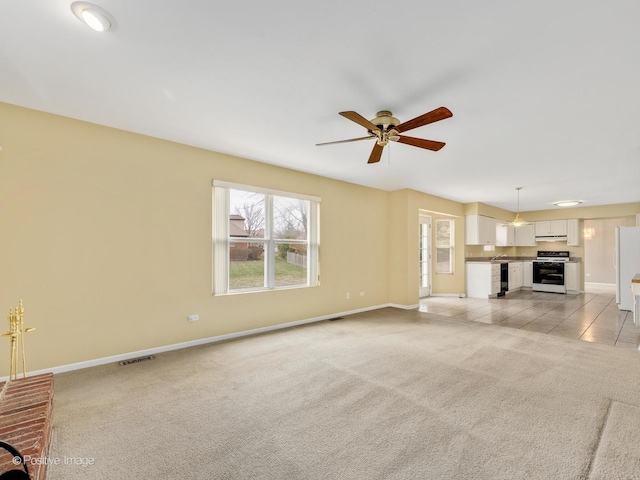 unfurnished living room with ceiling fan and light colored carpet