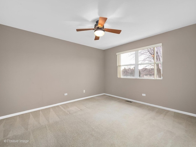 carpeted spare room featuring ceiling fan