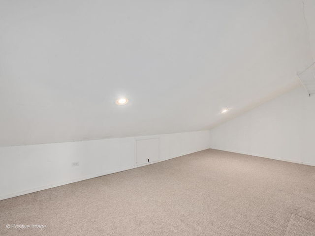 additional living space with carpet flooring and vaulted ceiling