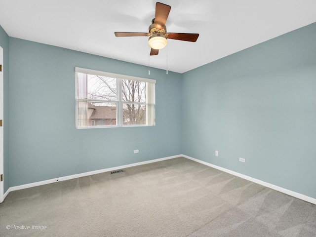 carpeted spare room featuring ceiling fan