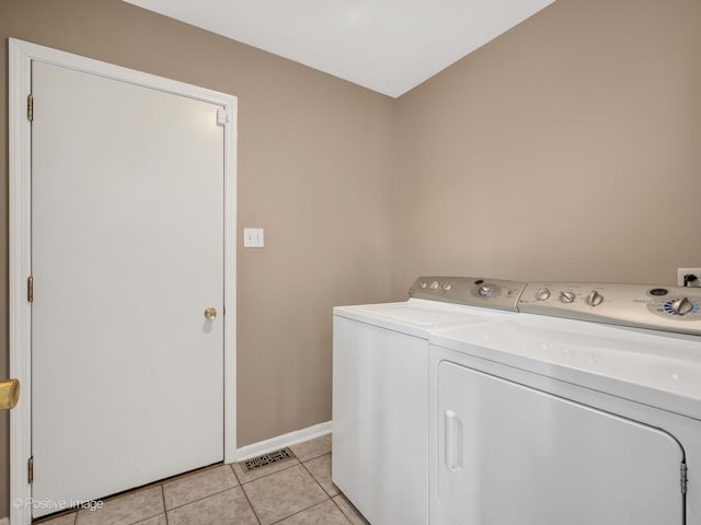 laundry area featuring light tile patterned flooring and separate washer and dryer