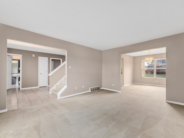 carpeted empty room featuring an inviting chandelier and sink