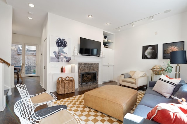 living area with built in features, recessed lighting, dark wood-style flooring, and a fireplace