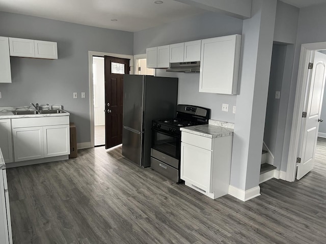 kitchen with sink, black refrigerator, dark hardwood / wood-style flooring, gas range oven, and white cabinets