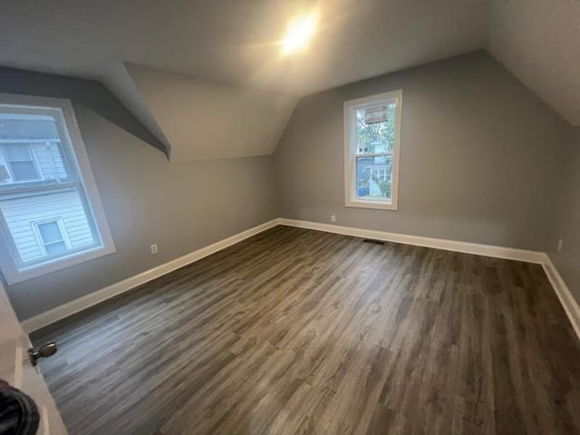 bonus room featuring vaulted ceiling and dark hardwood / wood-style floors