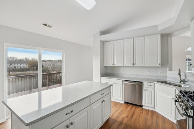 kitchen featuring appliances with stainless steel finishes, dark hardwood / wood-style flooring, sink, and white cabinets