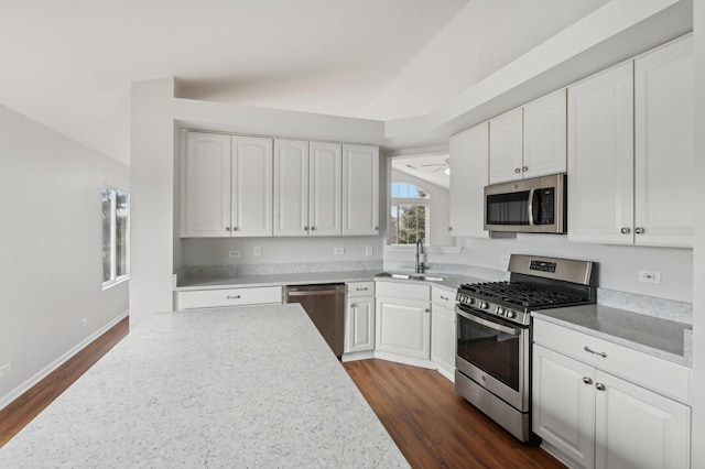 kitchen featuring sink, dark wood-type flooring, stainless steel appliances, and white cabinets