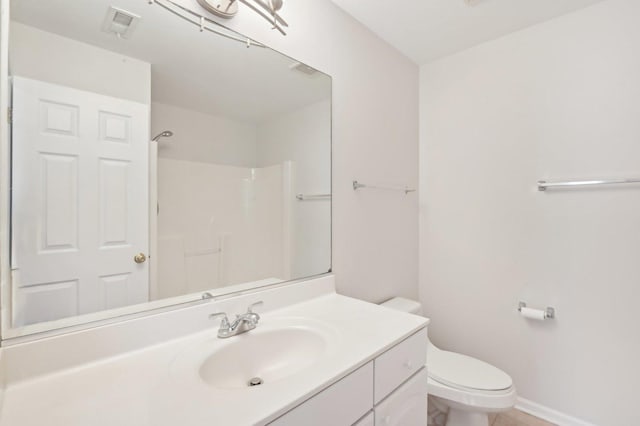 bathroom with vanity, walk in shower, and toilet