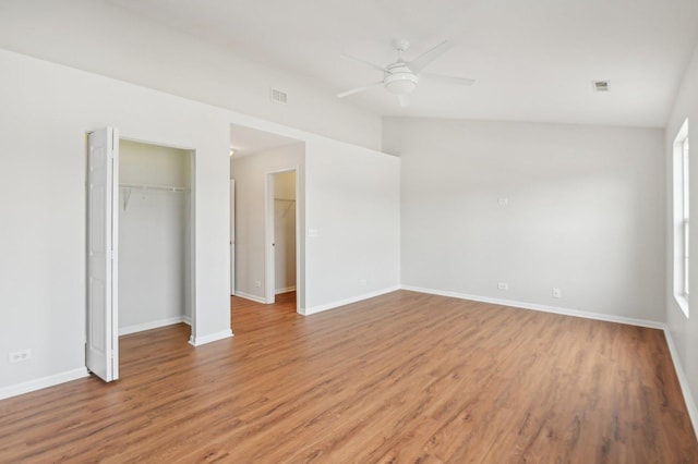 unfurnished bedroom featuring vaulted ceiling, a closet, ceiling fan, and light hardwood / wood-style flooring