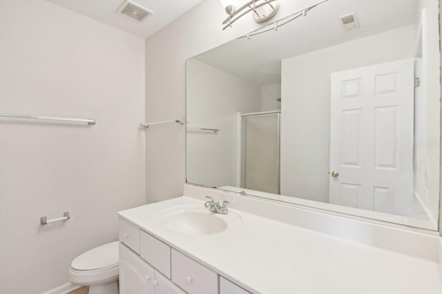 bathroom with vanity, an enclosed shower, and toilet