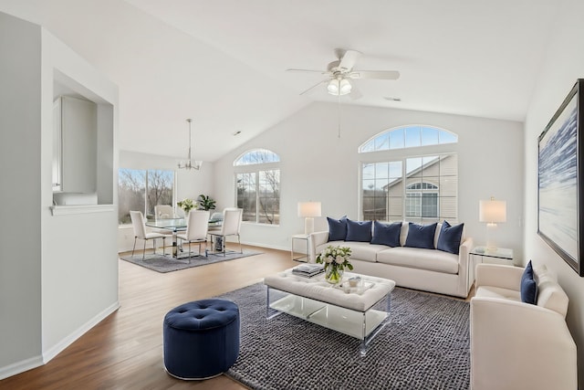 living room featuring lofted ceiling, hardwood / wood-style floors, and ceiling fan with notable chandelier