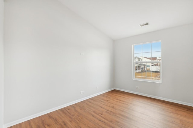 unfurnished room with wood-type flooring and vaulted ceiling