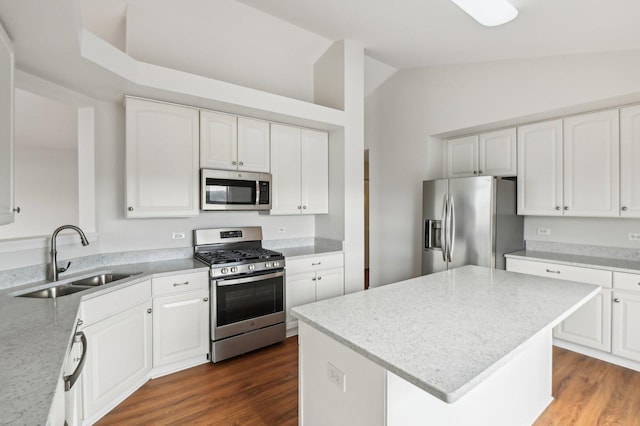 kitchen with a kitchen island, appliances with stainless steel finishes, sink, white cabinets, and dark wood-type flooring