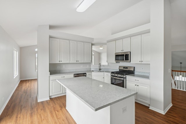 kitchen featuring white cabinetry, sink, stainless steel appliances, and a center island