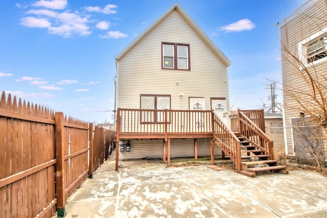 rear view of house featuring a wooden deck and a patio area