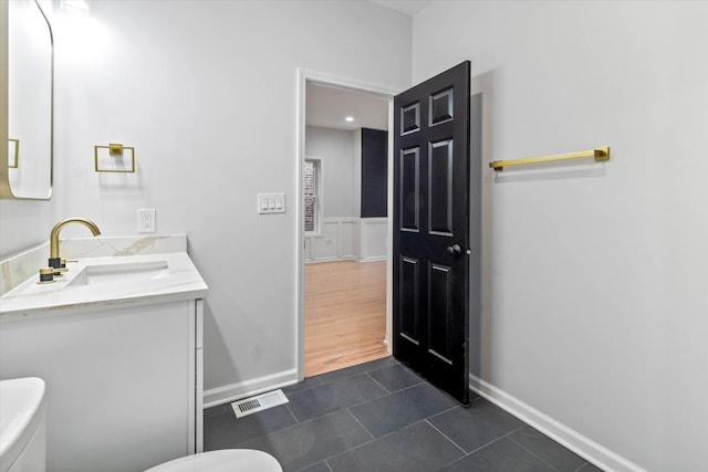 bathroom featuring vanity, tile patterned flooring, and toilet