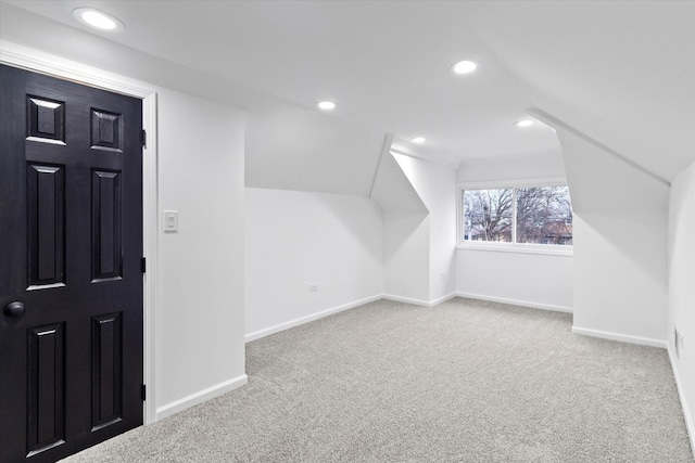 additional living space with lofted ceiling and light carpet