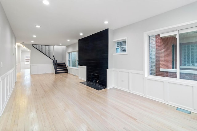 unfurnished living room with a fireplace and light hardwood / wood-style flooring