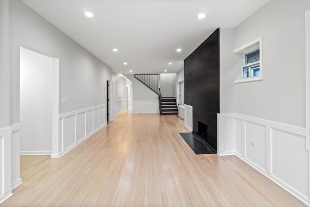 living room with a large fireplace and light hardwood / wood-style flooring