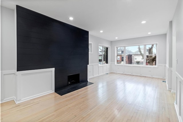 unfurnished living room with a fireplace and light hardwood / wood-style flooring