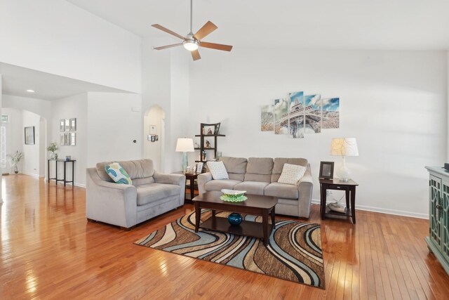 1616 Colchester Ln, Aurora, IL 60502 - living room with arched walkways, hardwood / wood-style flooring, a ceiling fan, baseboards, and a towering ceiling