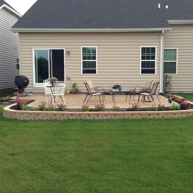 rear view of house featuring a patio area and a lawn