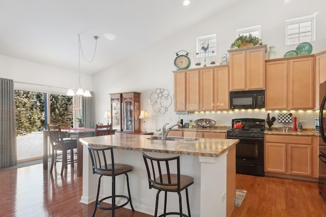 1616 Colchester Ln, Aurora, IL 60502 - kitchen with black appliances, a sink, backsplash, a chandelier, and high vaulted ceiling