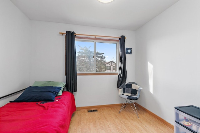 bedroom featuring wood finished floors, visible vents, and baseboards