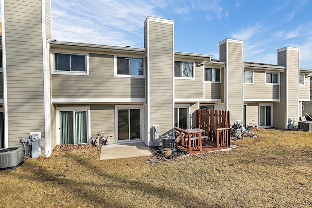 back of house featuring a patio area, a yard, a chimney, and central air condition unit