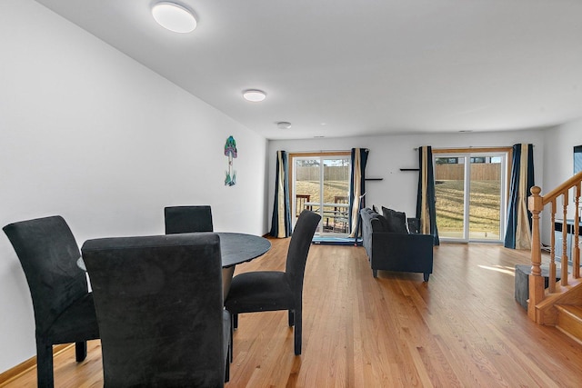 dining room featuring light wood-style flooring and stairs