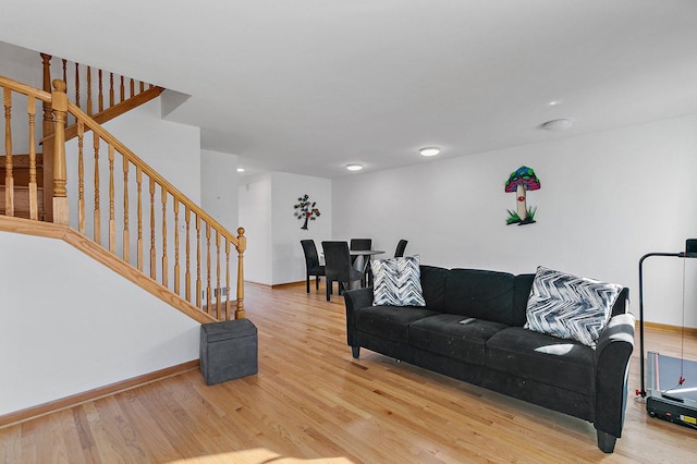 living room with baseboards, stairway, and light wood-style floors