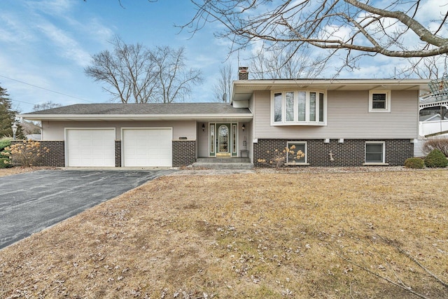 split level home with a garage and a front yard