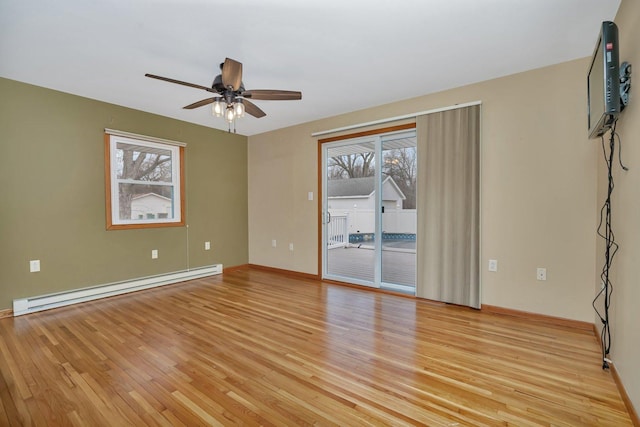 spare room featuring ceiling fan, light hardwood / wood-style floors, and a baseboard heating unit