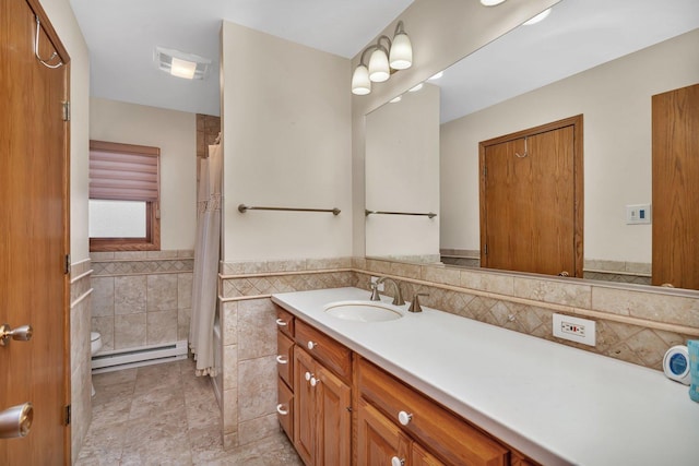 bathroom with tile patterned floors, toilet, tile walls, a baseboard radiator, and vanity