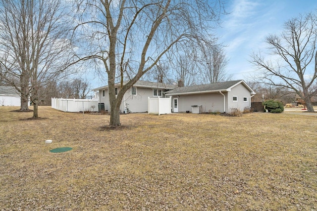 rear view of property featuring a lawn