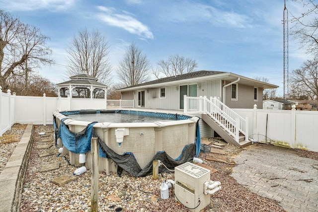 back of house featuring a fenced in pool and a gazebo