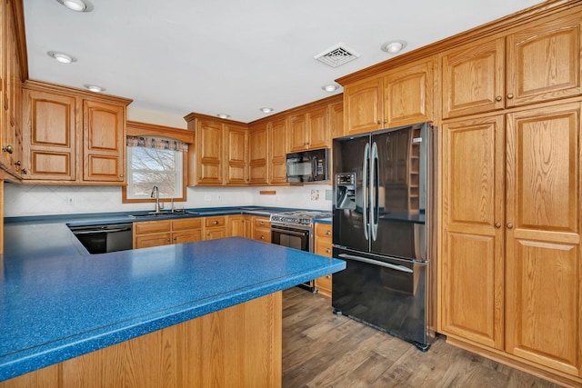 kitchen featuring dark hardwood / wood-style flooring, sink, backsplash, and black appliances