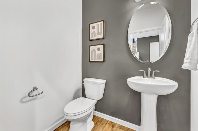 bathroom with hardwood / wood-style flooring, toilet, and sink